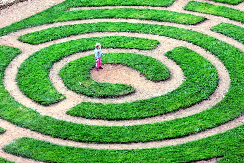 Un enfant au milieu d'un labyrinthe, évoquant le questionnement, et la perte de sens