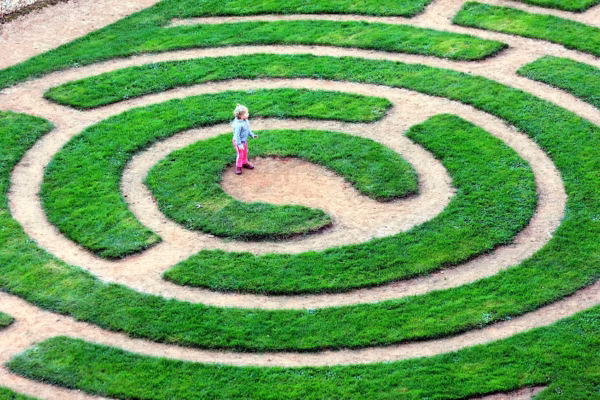 Enfant au centre d’un labyrinthe de verdure, symbole des schémas répétitifs et des blocages intérieurs