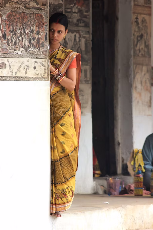 Jeune femme indienne en tenue traditionnelle, appuyée contre un mur, regard discret, illustrant la sensation intérieure de stagnation quand rien ne change vraiment.