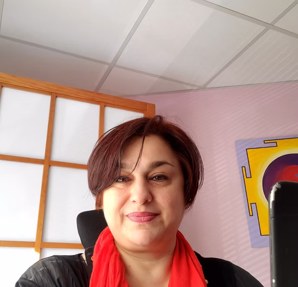 Portrait souriant et accueillant d’une thérapeute en ligne, illustrant une présence bienveillante, sécurisante et attentive.